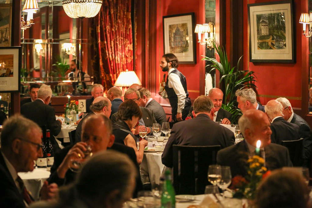 Members dining in a red-panelled private dining room