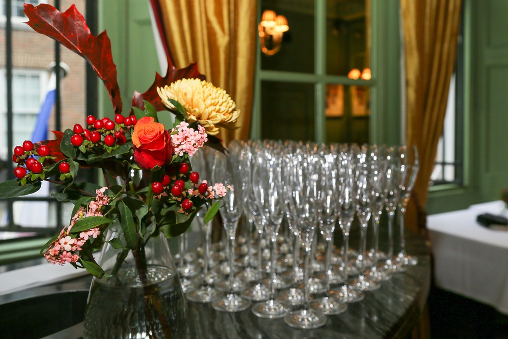 Flowers and champagne flutes laid out in a sunlit reception room